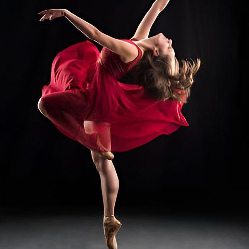 Ballet dancer in red dress performing gracefully.