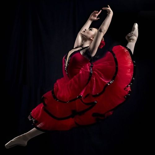 Ballet dancer leaping in red dress.