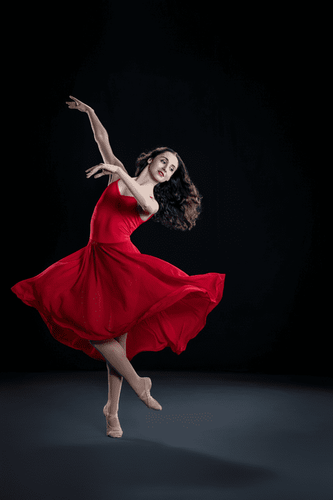 Ballet dancer in flowing red dress mid-twirl